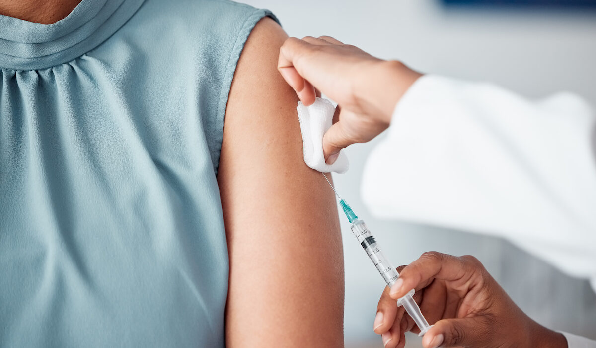 Hands, medical and doctor with patient for vaccine in a clinic for healthcare treatment for prevention. Closeup of a nurse doing a vaccination injection with a needle syringe in a medicare hospital.