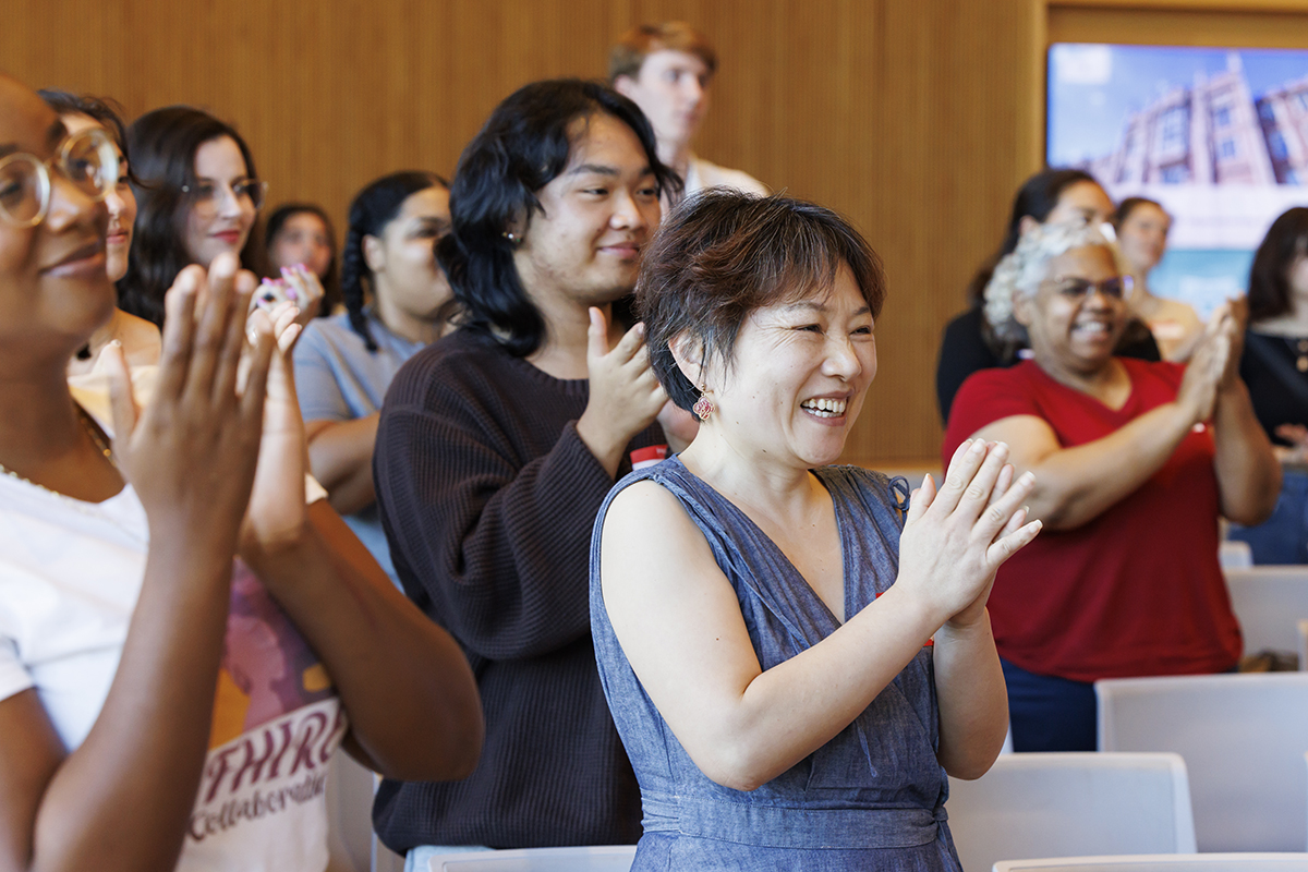 Audience members applaud speakers