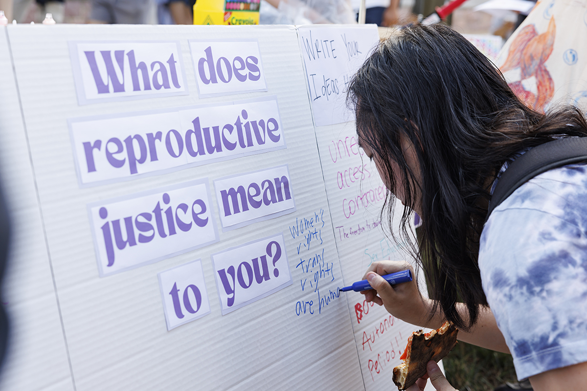 student signs a poster