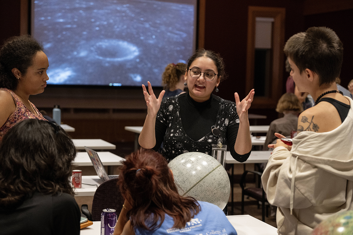 Student speaks with group