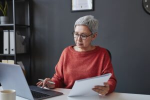 older woman looks at a laptop