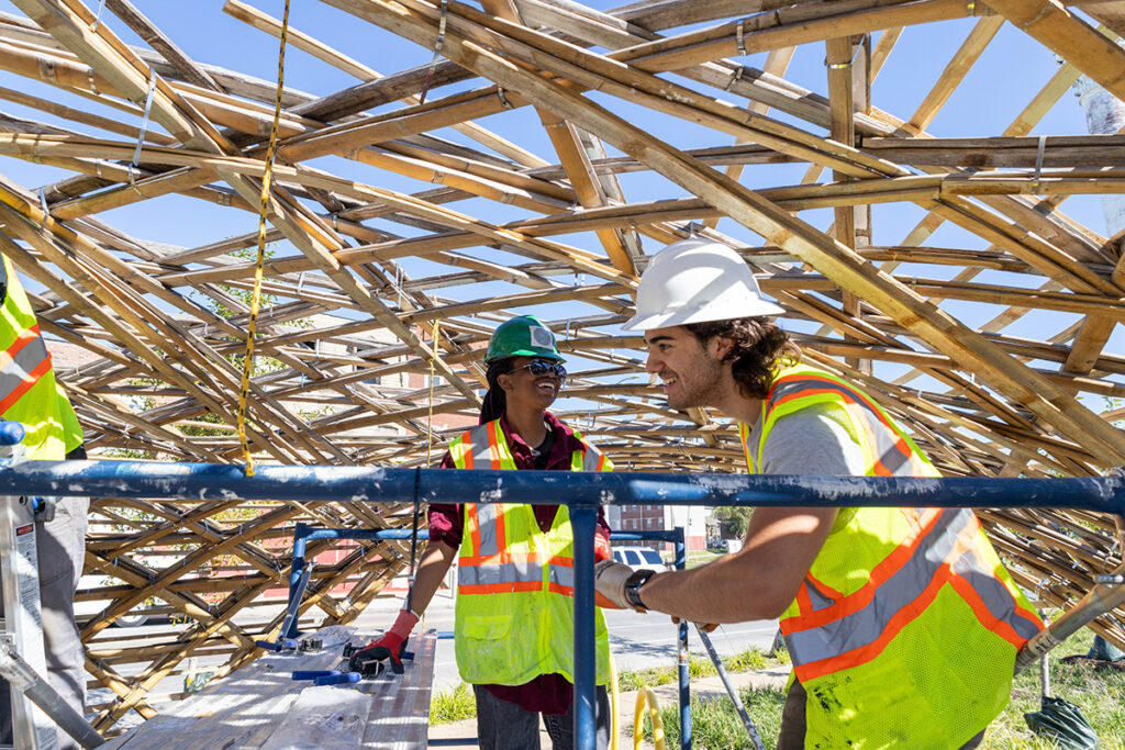 Two people conduct maintenance on structure