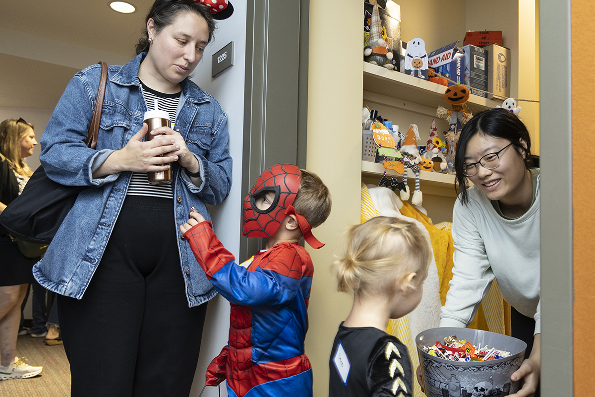 Student hands out candy to children