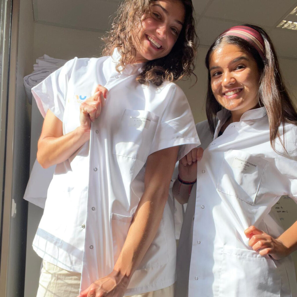 Students proudly wearing their hospital uniforms provided by the Hôpital Pasteur, ready for their medical internships. (Courtesy photo)