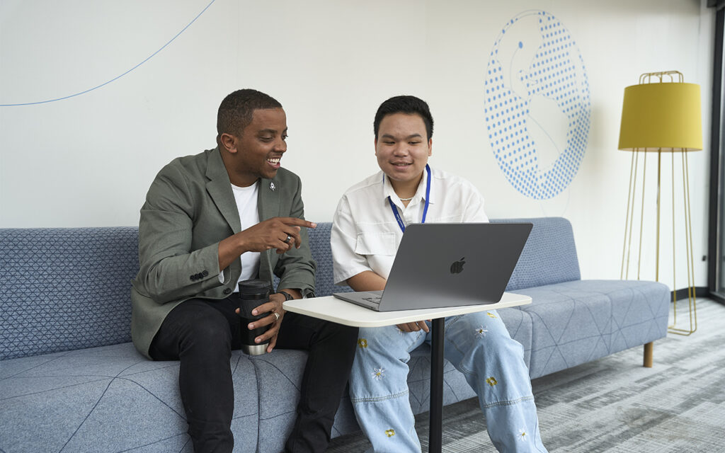 Goldman Fellow Dung Tran (right), a sophomore at Olin Business School, interned at LaunchCode, where he tracked job outcomes for graduates. Tran was mentored by LaunchCode CEO and Goldman Fellow alum Julian Nicks, BSBA ’13, who says his own experience with the program played a key role in his own professional development. (Photo: Theo Willing/WashU)