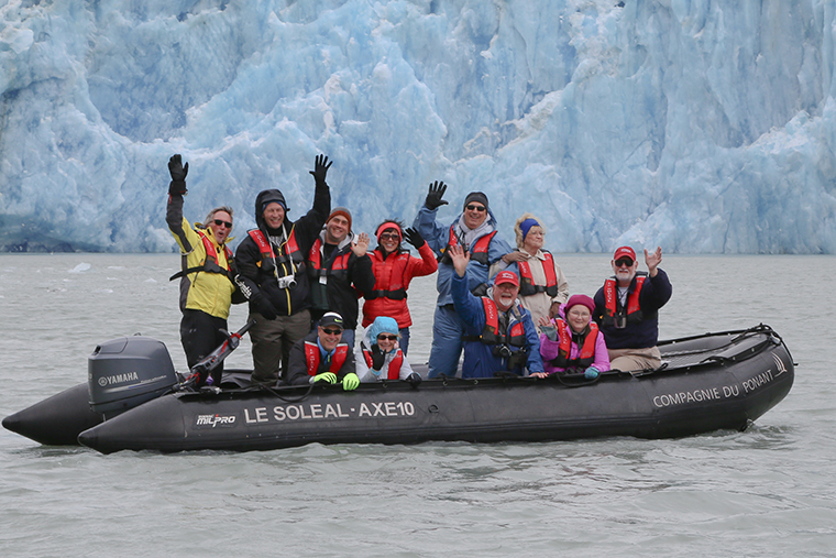 David Fike (standing third from left) helps WashU alumni experience Alaska's immense glaciers up close. (Courtesy photo)