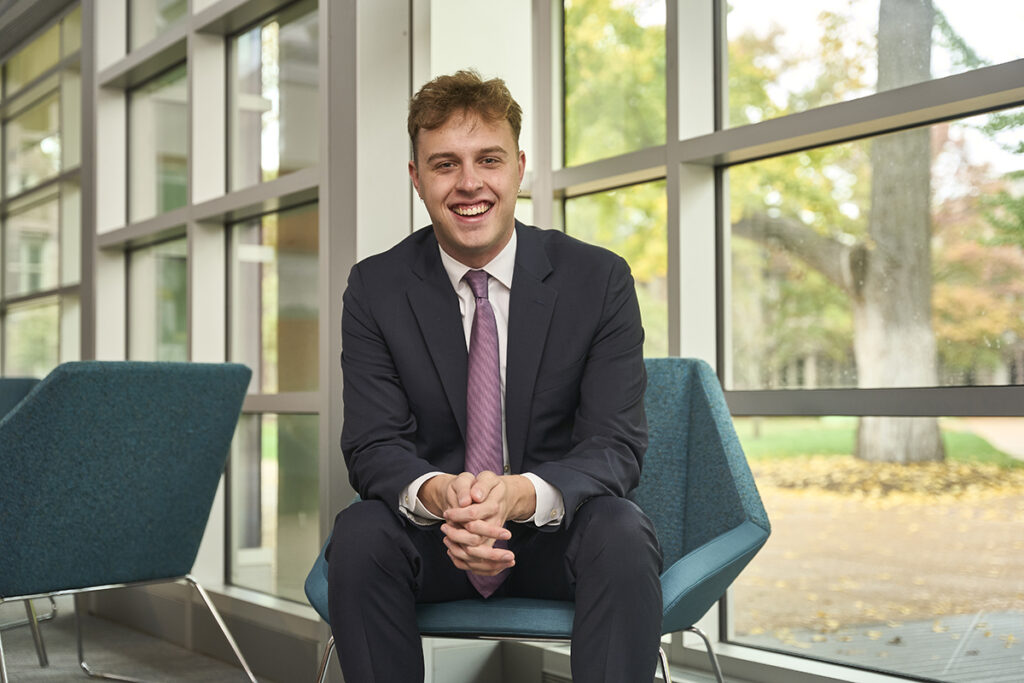 Portrait of student Isaac Welling sitting in a library