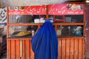 a woman in a burqa tries to get food