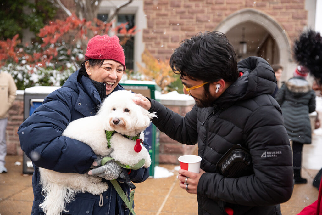 students pet a white dog