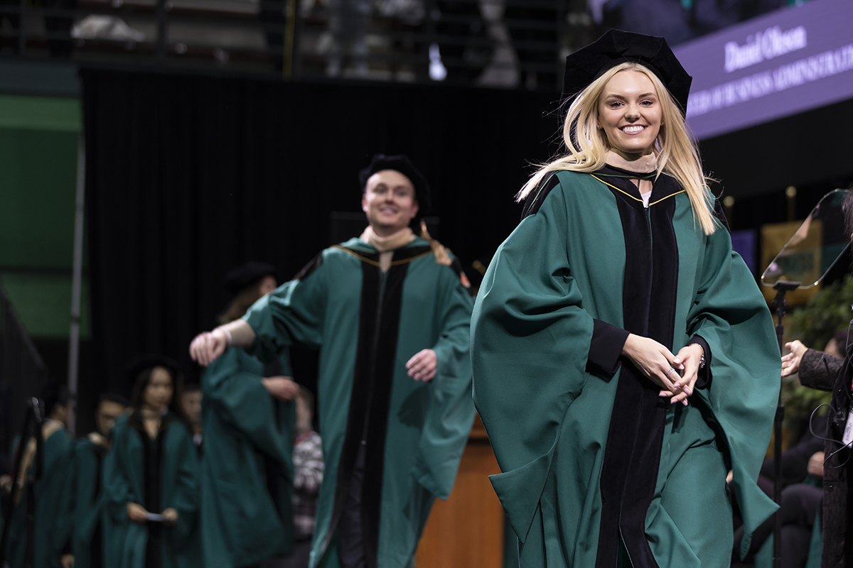 Graduates walk across the stage