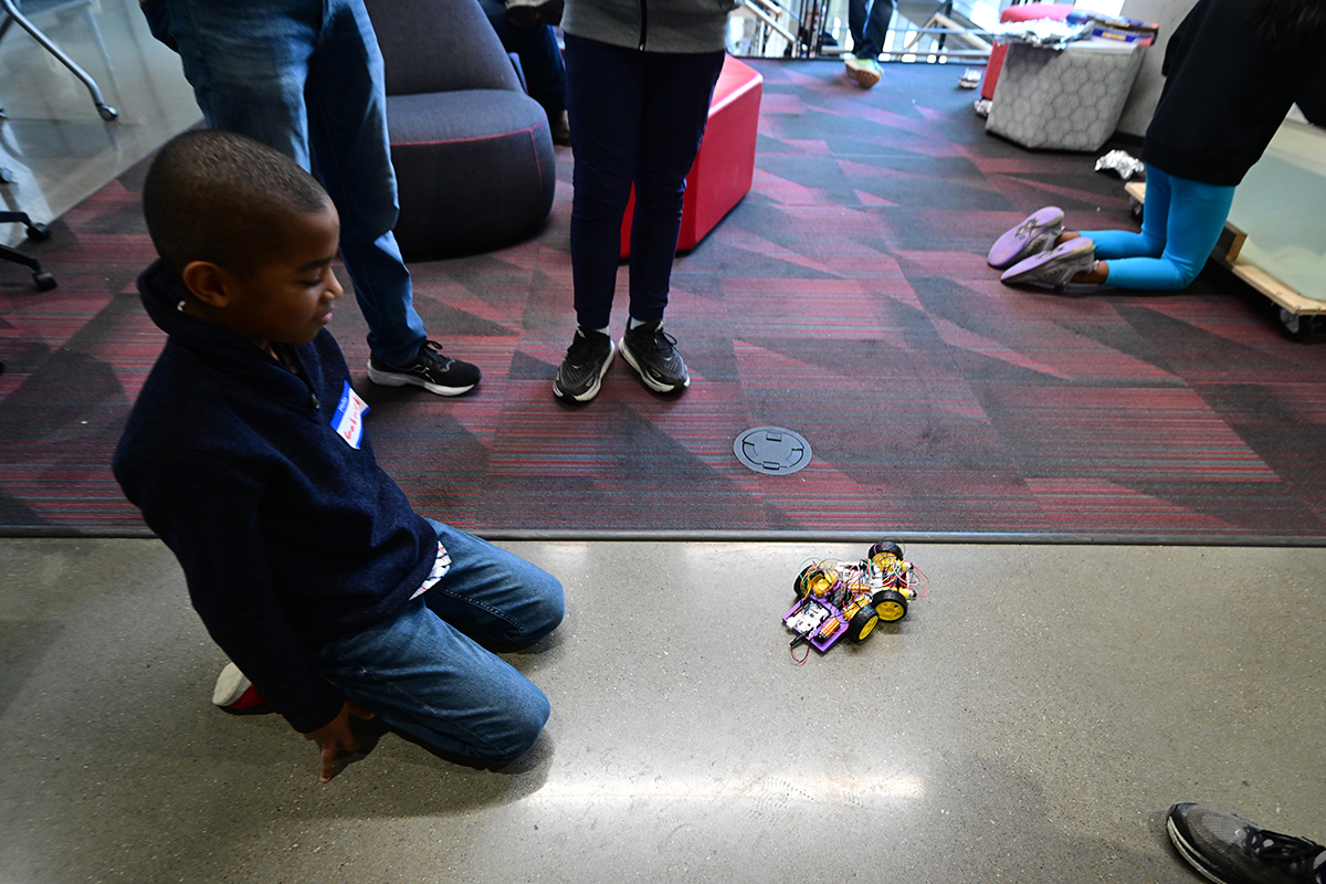 A child looks at a robot