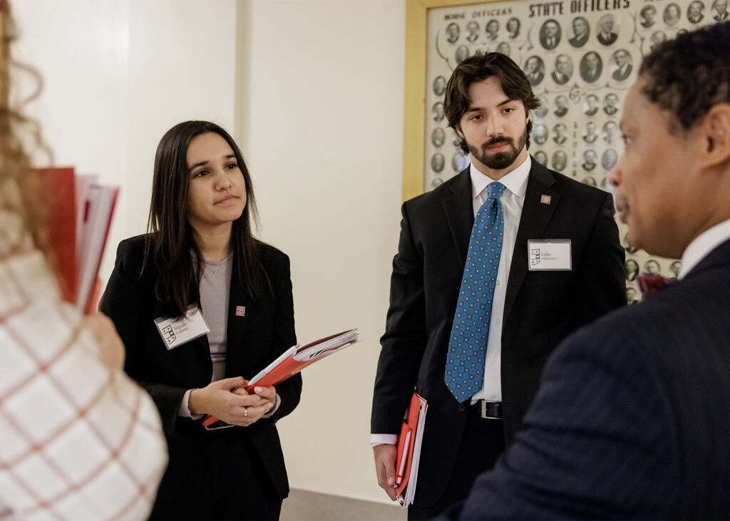 WashU students Megan Manaj (left), Nicole Lukens (center) and Luke Johnston speak with Missouri state Rep. Del Taylor. (Photo: Whitney Curtis/WashU)