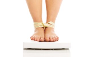 feet on a scale all tangled in measuring tape