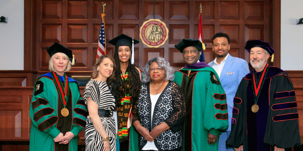 The Washington Family gathered in the Bryan Cave Moot Courtroom for a celebratory portrait after ceremony. (From left:) Stefanie Lindquist, the Nickerson Dean and professor of law; Leslie Demourelle, Washington’s wife; McKenzie Washington; Ada Washington; Judge Washington; his son Washington; and Michael M. Greenfield, the George Alexander Madill Professor of Contracts & Commercial Law Emeritus.