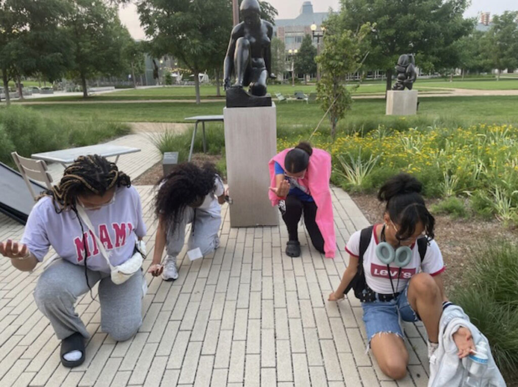 Students pose with a sculpture at WashU