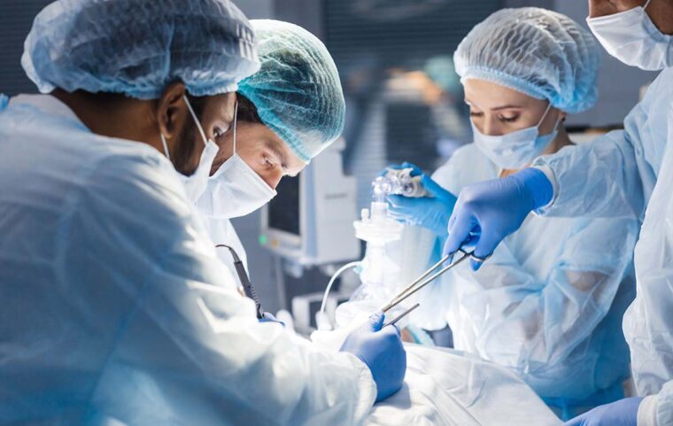 surgeons at work around a person in an operating room