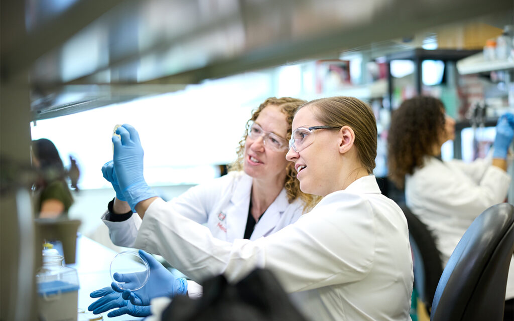 Christina Stallings, PhD (left) works with postdoctoral research associate Abigail Garrett, PhD. In the Stallings lab, researchers look for ways <i>M. tuberculosis</i> defends itself against the immune system and survives antibiotic treatment. (Photo: Matt Miller/WashU Medicine)