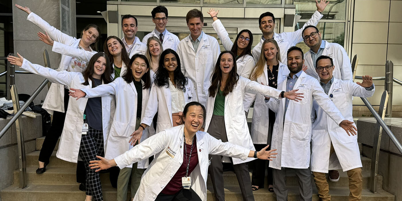 Jennifer Yu (center front) and the most recent class of general surgery interns during orientation in June 2024. Yu is an example of an alum who has built a professional life at WashU after earning degrees here.