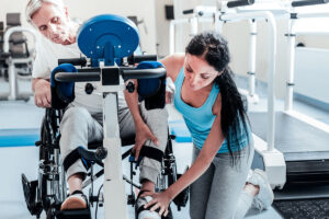 a trainer helping a man on a recovery machine
