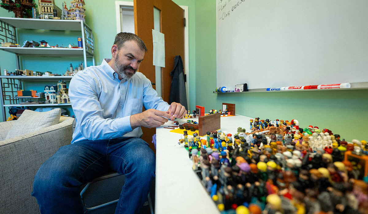 A man with a table full of legos
