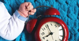 Baby holds analog alarm clock