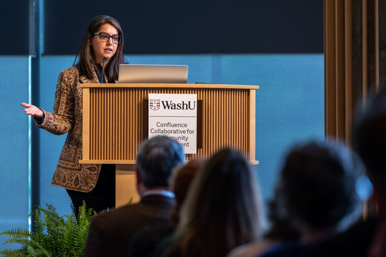 A professor stands at a podium discussing her research