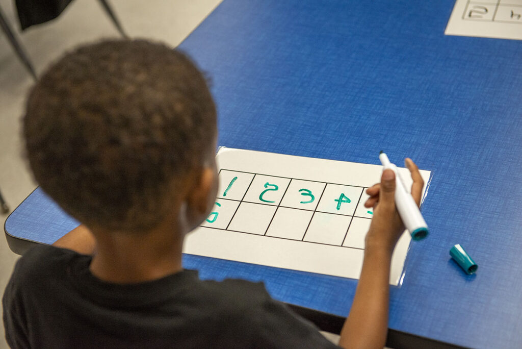 A pre-k student works on a math assignment